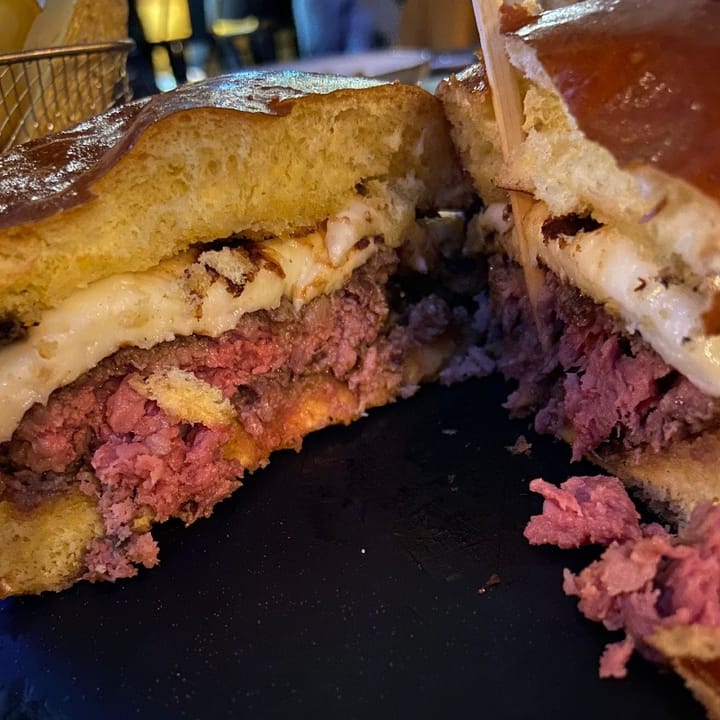 Cut through the centre of a rare hamburger topped with halloumi cheese, in a brioche bun