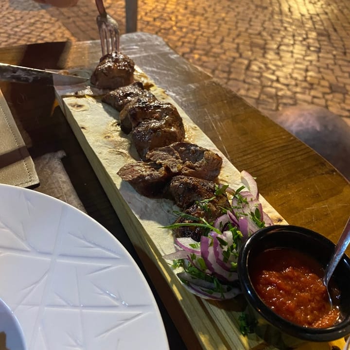 Chunks of lamb chargrilled on a skewer and served on a thin sheet of flatbread with tomato sauce