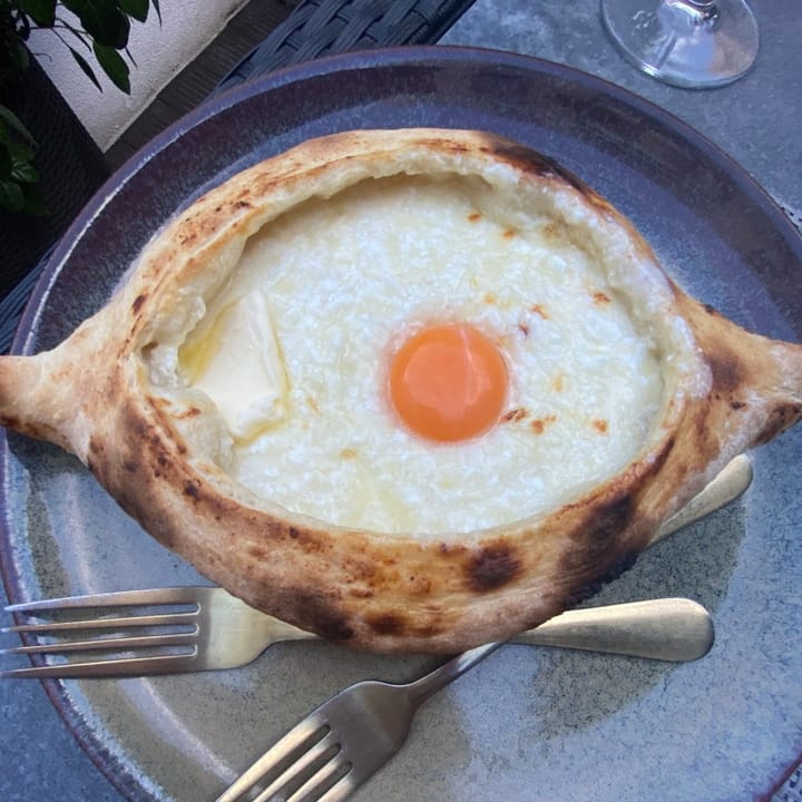 Crispy baked bread filled with melted cheese and a sunny-side up egg